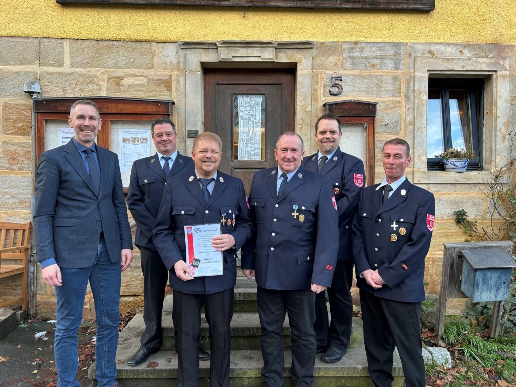 Bürgermeister Martin Bernreuther und Kreisbrandmeister Jörg Schneider überreichen das Bayerische Feuerwehrehrenzeichen in Gold an Jürgen Thormeyer.